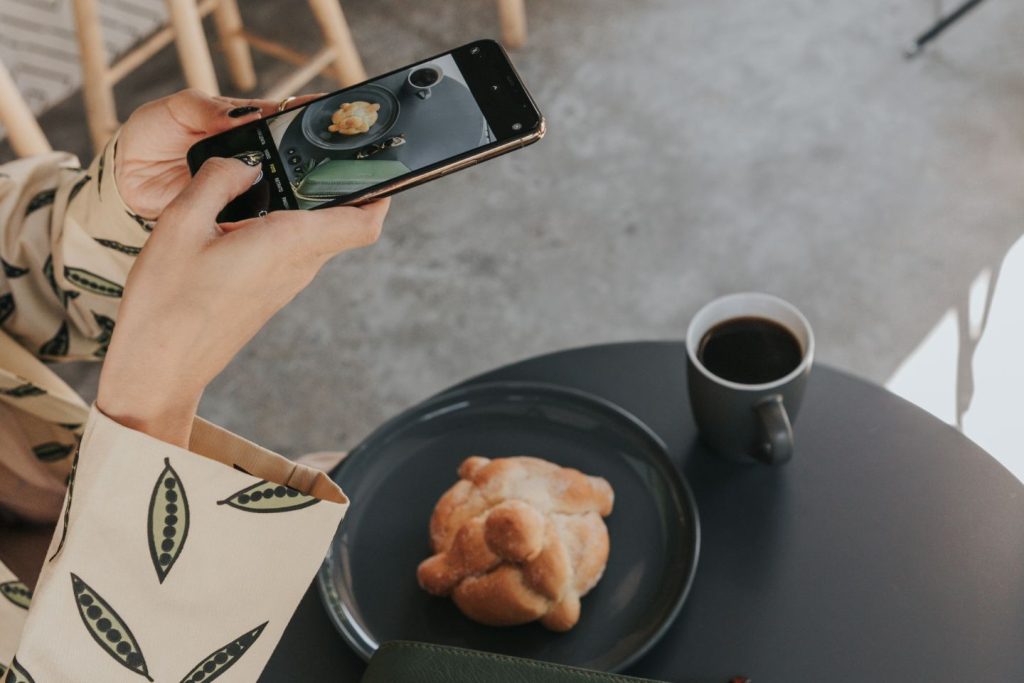 marketing expert taking image of her pastry and coffee